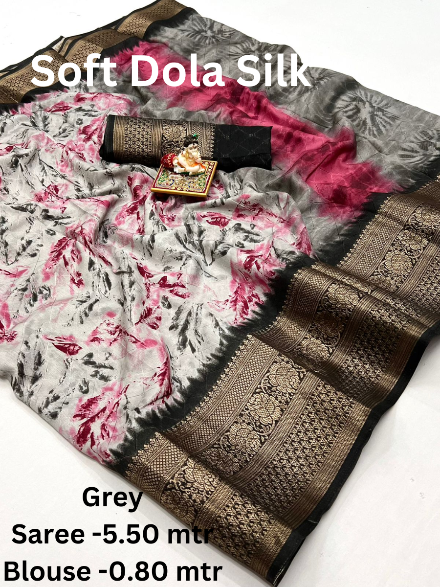 A Grey Soft Dola Silk Saree with a large, intricately woven border and a double shaded effect. The saree comes with a matching blouse piece.